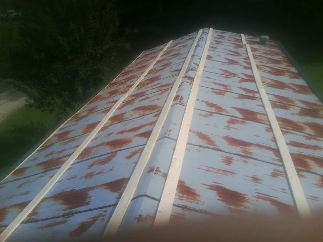 Rusted metal roof panels with new wood purlins before replacement — Storm Damage Roof Repair in Revere by Roofing Brothers
