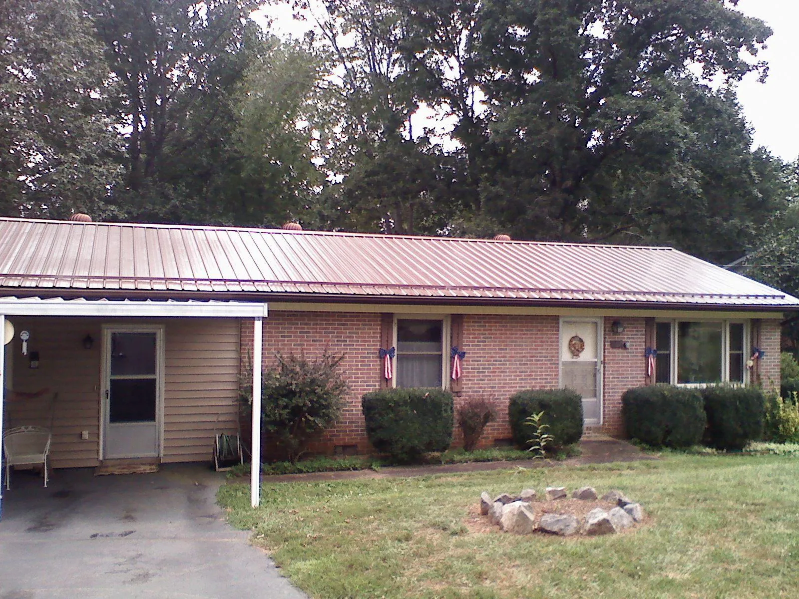 Bronze metal roof and carport on a brick ranch home — Roof Repair work by our crew in Revere