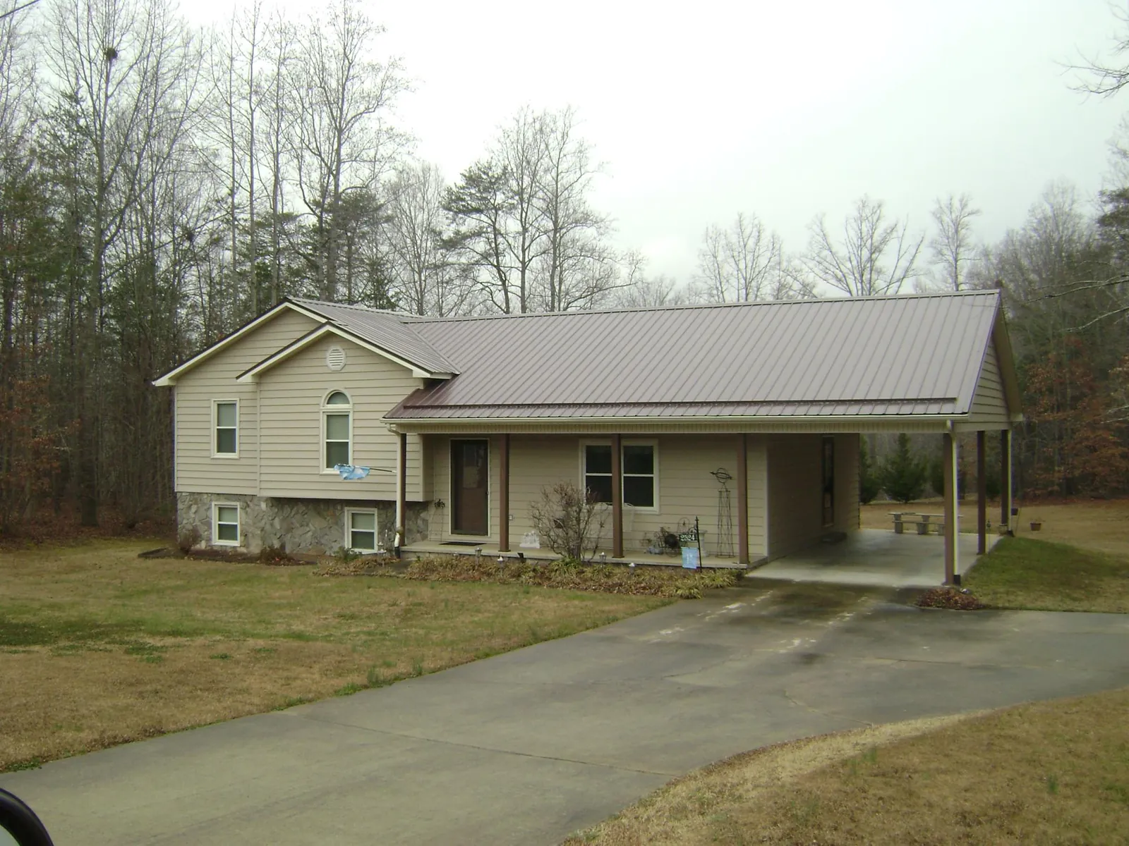 Brown metal roof on a tan split level home with an attached carport in Revere